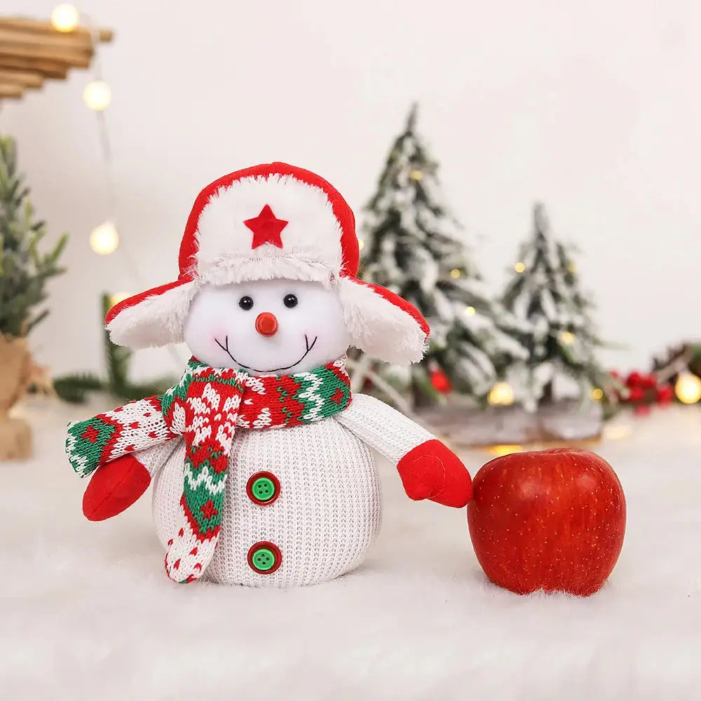 a snowman with a hat and scarf next to an apple