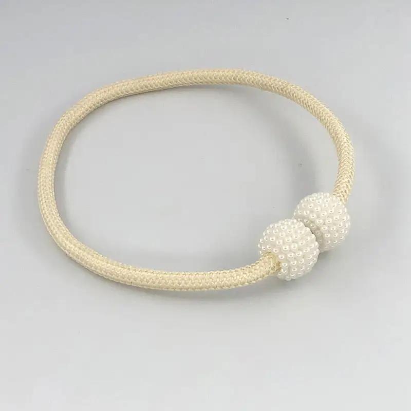 a white beaded bracelet on a white background