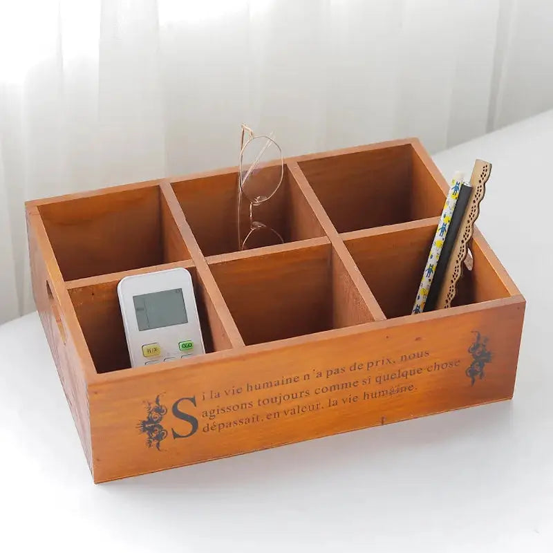 a wooden box with a cell phone and pencils in it
