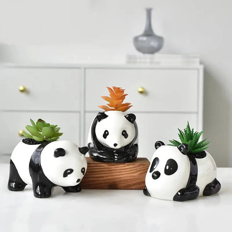 a group of three panda bears sitting on top of a table