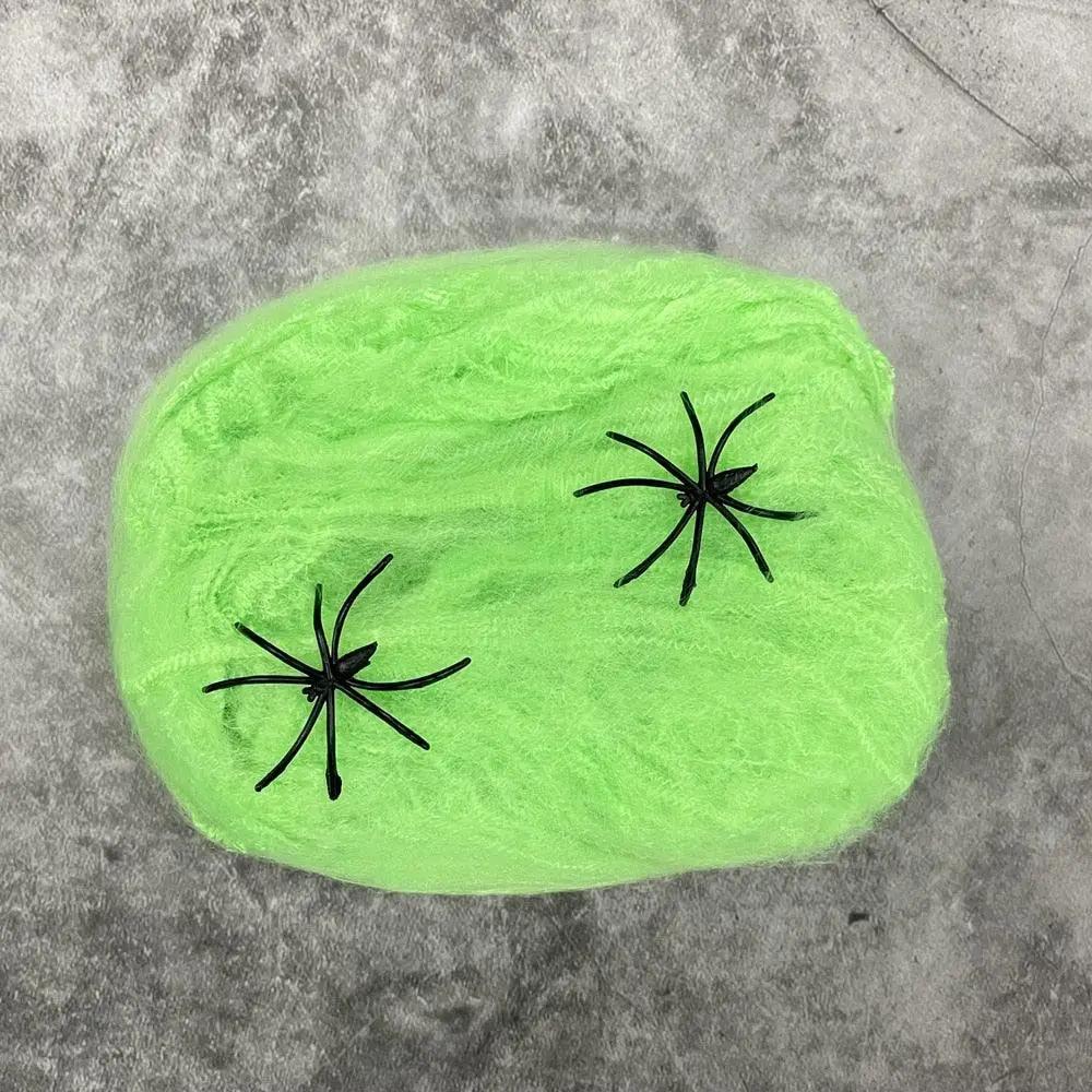 a green rock with two black spider legs on it