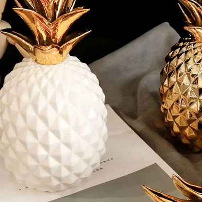 a white and gold pineapple vase sitting on top of a table