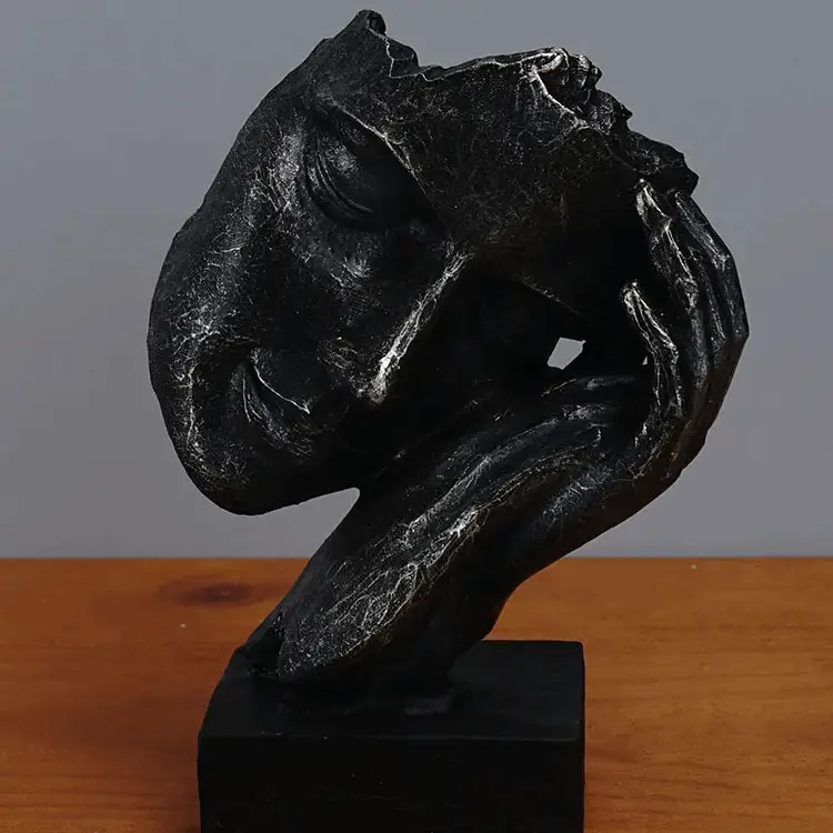 a black sculpture sitting on top of a wooden table