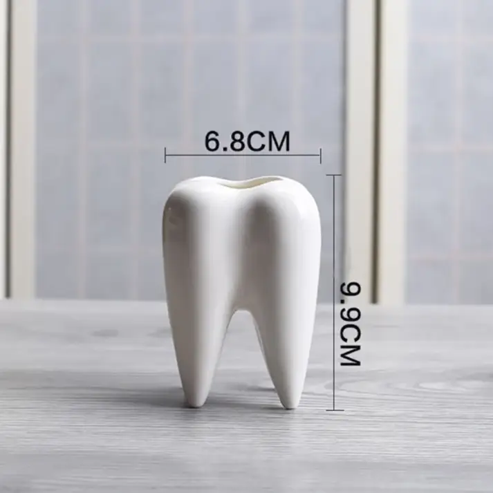 a tooth shaped toothbrush holder on a table