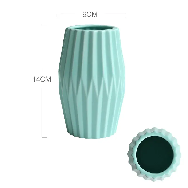 a blue vase sitting next to a green cup