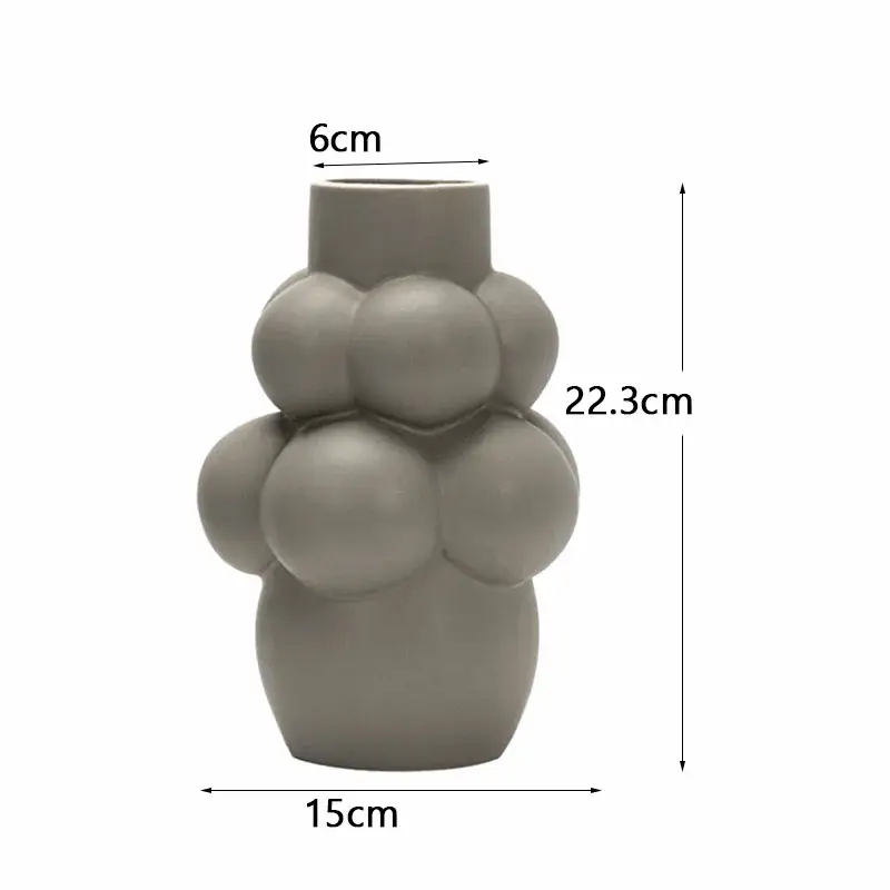 a gray vase with a bunch of balls on it