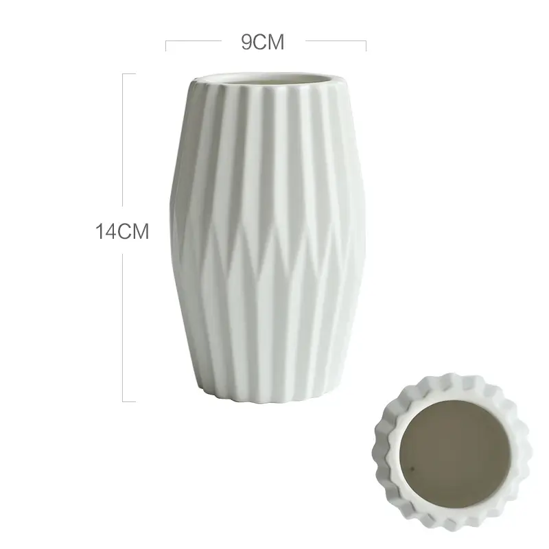 a white vase sitting next to a white cup