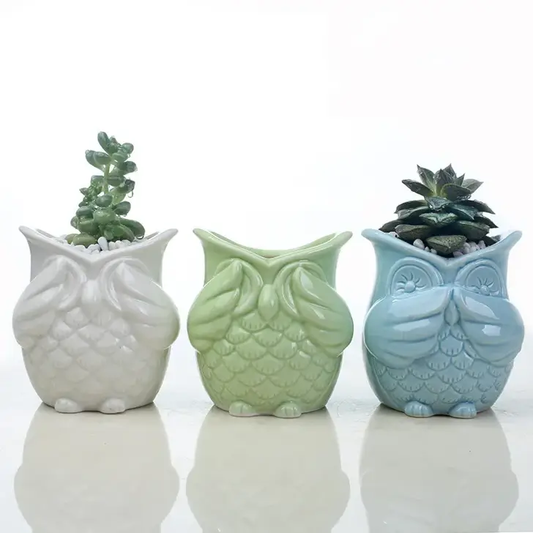 a group of three ceramic owls sitting next to each other