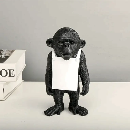 a statue of a monkey holding a paper