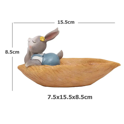 a toy rabbit sitting on top of a wooden boat