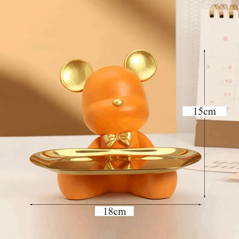 a yellow bear figurine holding a gold plate