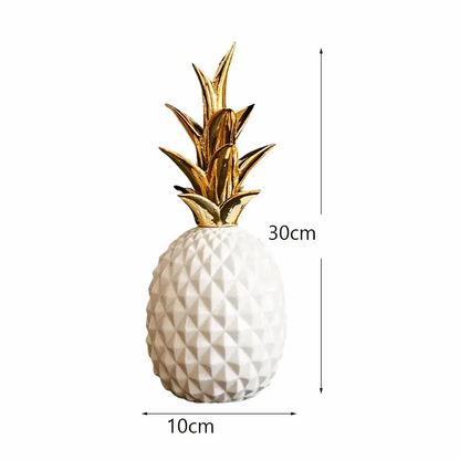 a white and gold pineapple shaped vase sitting on top of a table