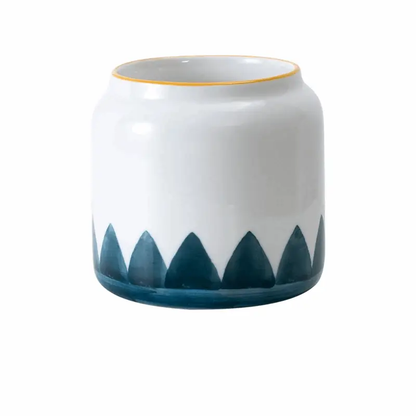 a white and blue vase with a yellow rim