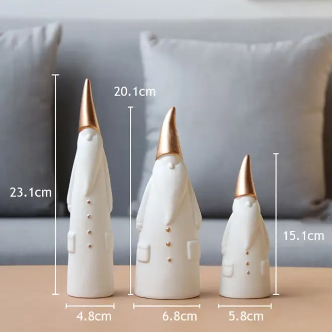 three white and gold ceramic cones on a table