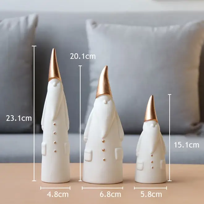 three white and gold ceramic cones on a table