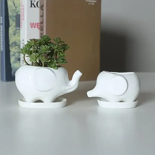 a couple of white elephants sitting on top of a table