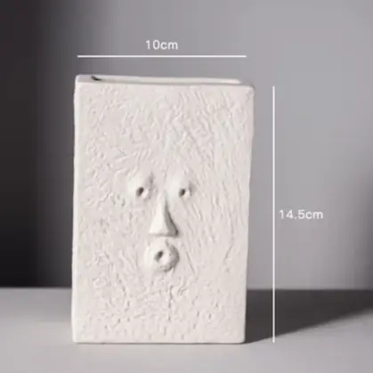 a white sculpture with a face on it