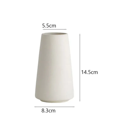 a tall white vase sitting on top of a table