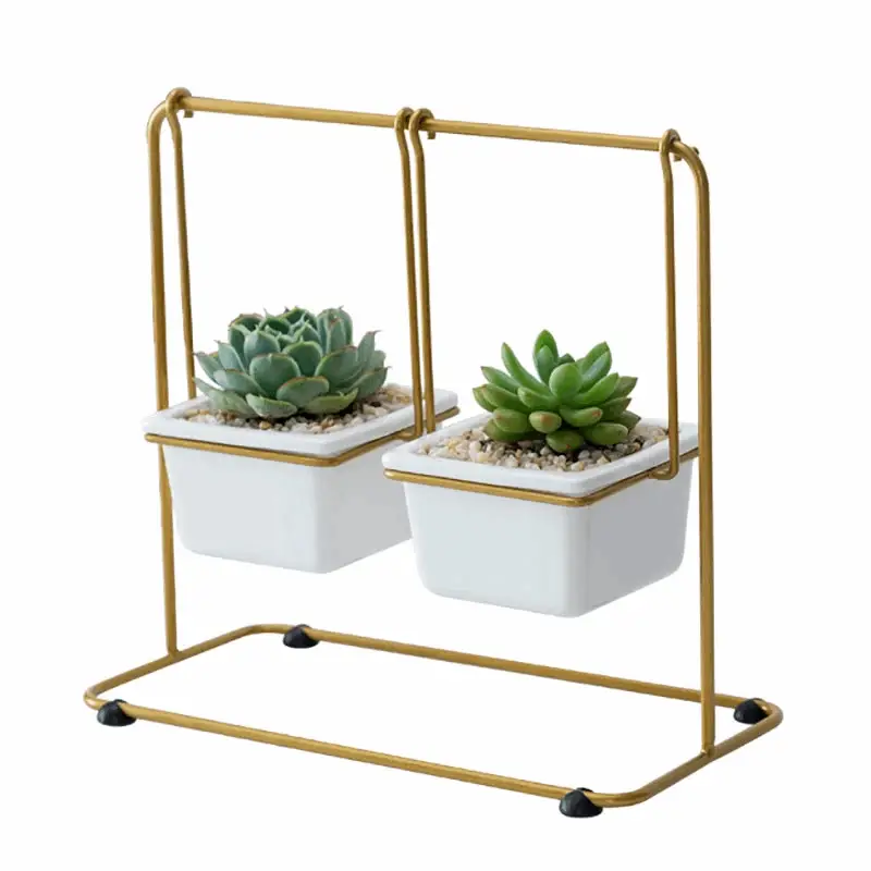 a pair of white planters sitting on top of a metal stand