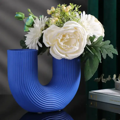 a blue vase with white flowers on a table