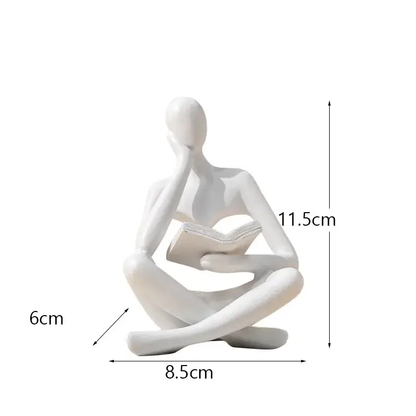 a white statue of a person sitting in a yoga position