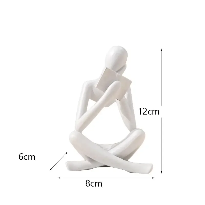 a white figurine of a person sitting on the ground