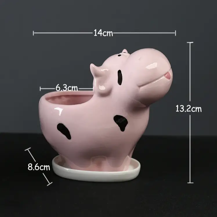 a pink ceramic pig planter sitting on top of a table