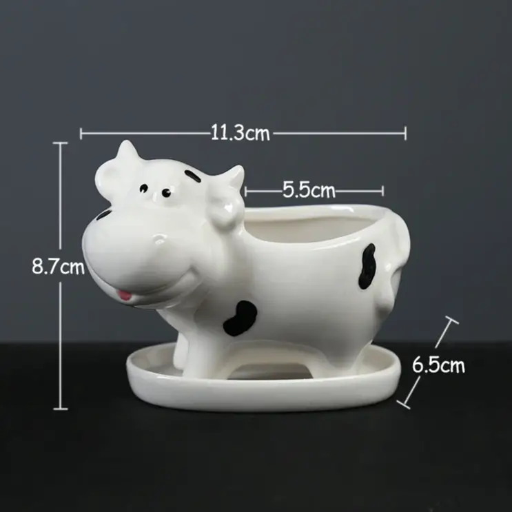 a ceramic cow planter is shown on a table