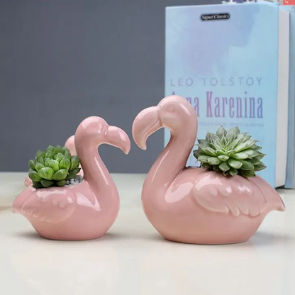 a couple of pink flamingos sitting on top of a table