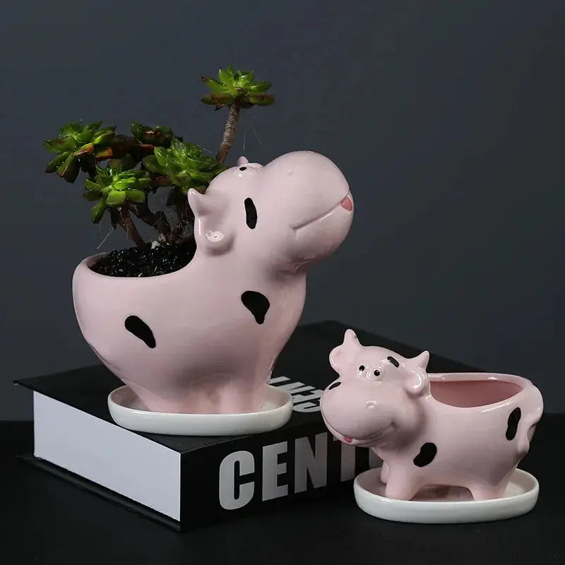 a pink ceramic pig planter next to a ceramic pig planter