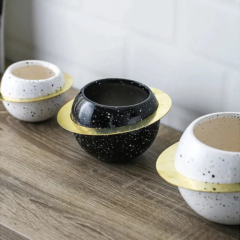 three black and white bowls sitting on top of a wooden table