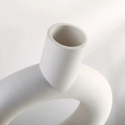 a white vase sitting on top of a white table