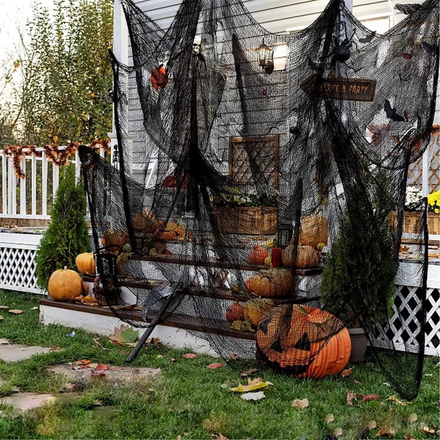 a house decorated for halloween with pumpkins and a net