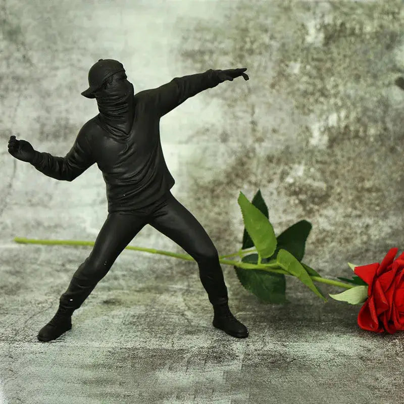 a statue of a man holding a baseball bat next to a red rose