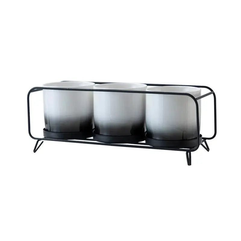 three black and white cups on a metal rack