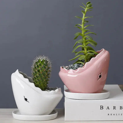 a pink and white planter sitting on top of a white box