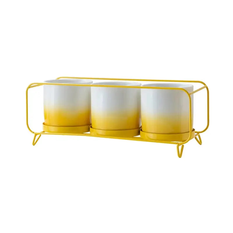 three yellow and white cups on a yellow stand