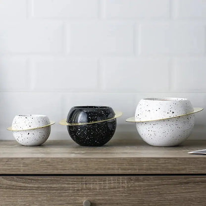 three black and white bowls sitting on top of a wooden table