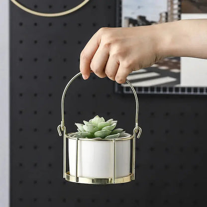 a person holding a small white and gold planter