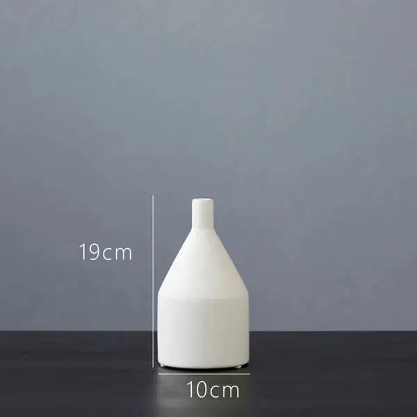 a white vase sitting on top of a table