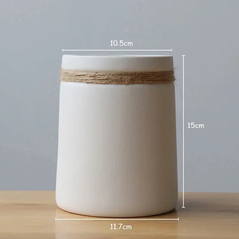 a white vase with a rope around it