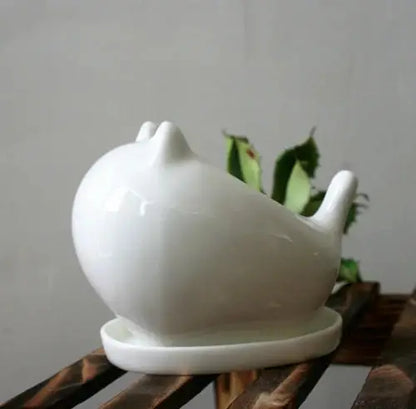 a white teapot sitting on top of a wooden table