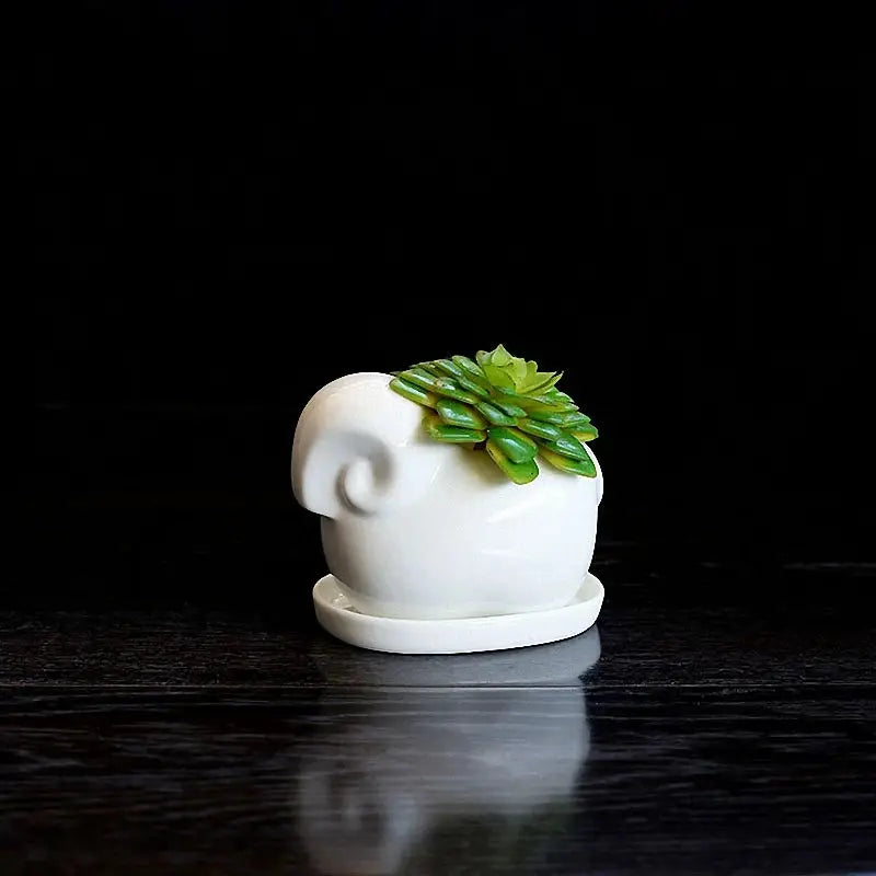a small white elephant shaped planter on a table