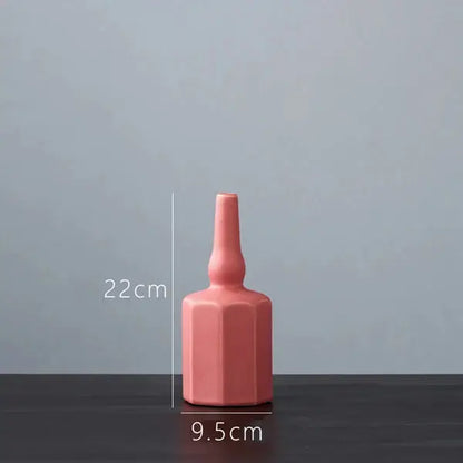 a pink vase sitting on top of a wooden table