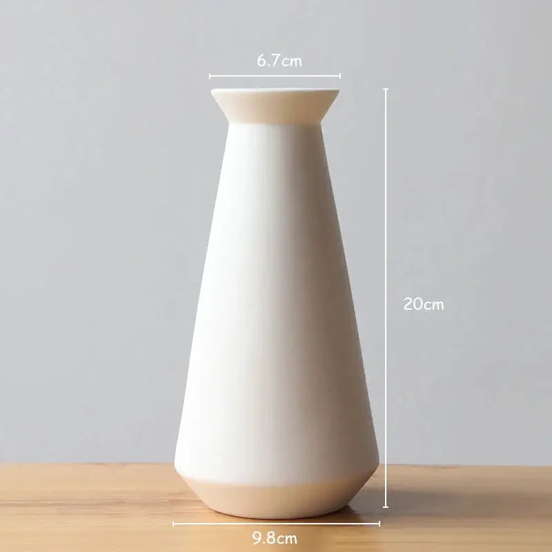 a white vase sitting on top of a wooden table