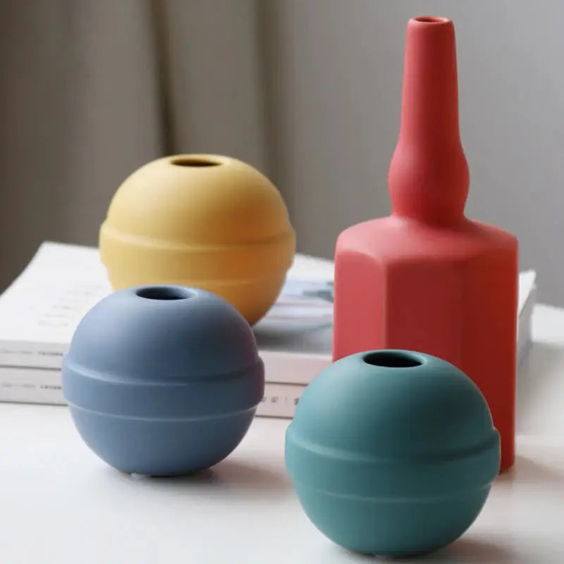 three different colored vases sitting on a table