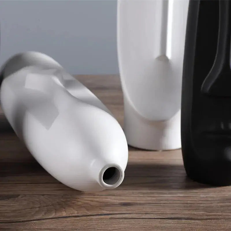 a couple of white vases sitting on top of a wooden table