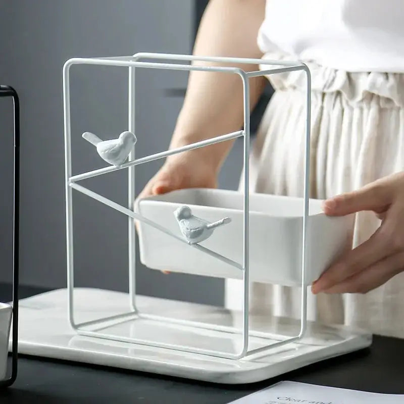 a person is holding a bowl in front of a bird cage