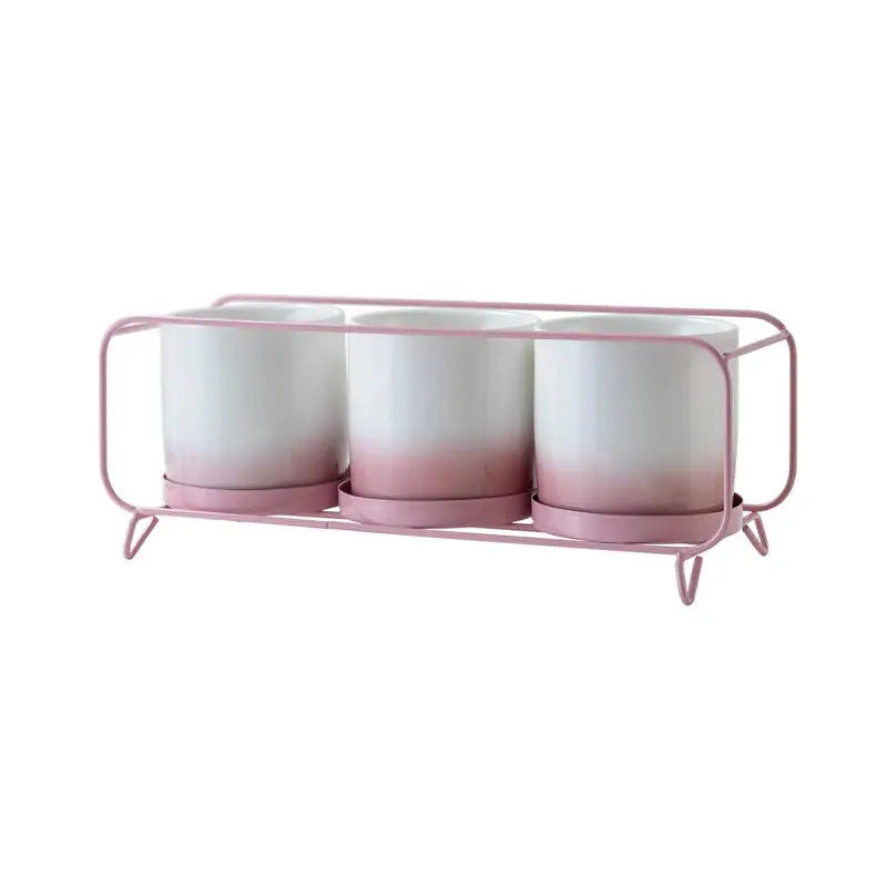 a pink and white candle holder with three candles