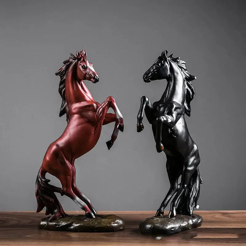 a couple of statues of horses on top of a wooden table